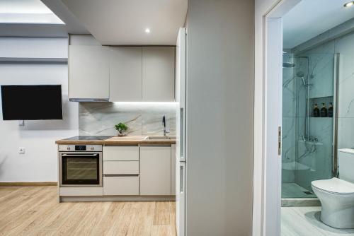 a kitchen with white cabinets and a toilet and a shower at Virginia Haven 2 in Chios