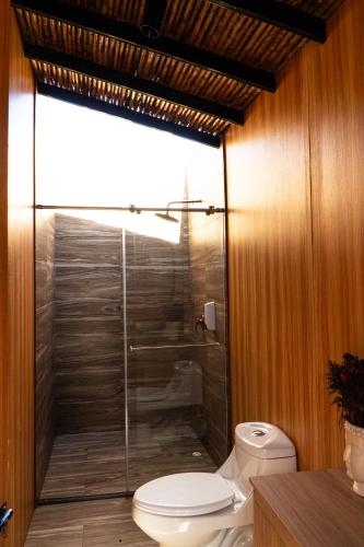 a bathroom with a toilet and a glass shower at Oasis Barichara in Barichara