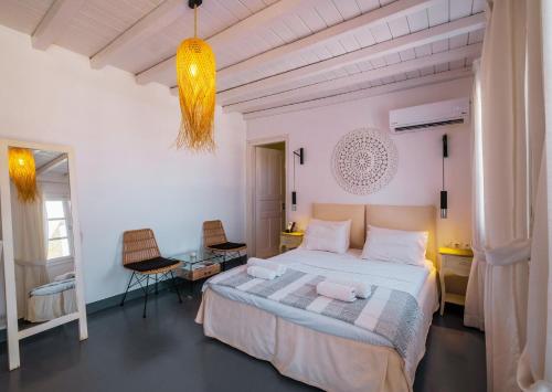 a bedroom with a bed and a table and a chair at Manu Mykonos Exclusive Villa Luxury Beachside Stay with Private Pool by Quality Brand Villas in Kalafatis