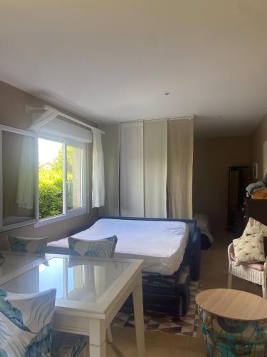 une chambre avec un lit, une table et une fenêtre dans l'établissement L Atelier Demoiselle, à Cadillac