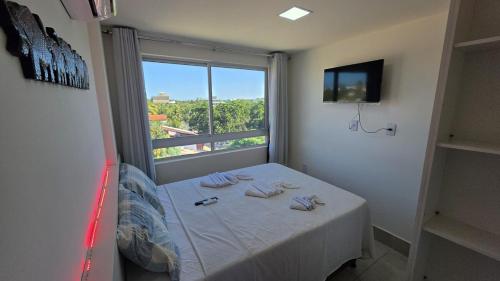 a room with a bed with a large window at Aline Duque 308 no Centro de Porto by La Playa in Porto De Galinhas