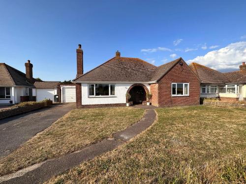 a house with a grass yard in front of it at Bayview Cottage in Bournemouth