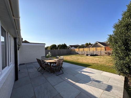a patio with a table and chairs on the side of a house at Bayview Cottage in Bournemouth