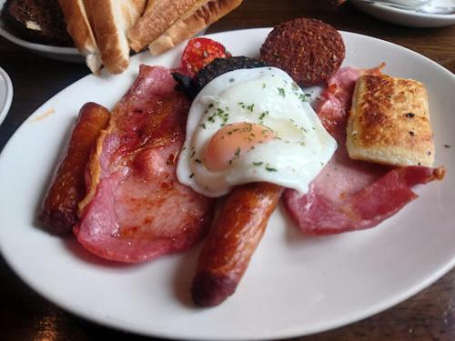 a plate of breakfast food with an egg and sausage at Cryans Hotel in Leitrim