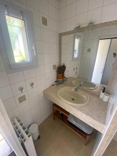 une salle de bain avec un lavabo et un miroir dans l'établissement L Atelier Demoiselle, à Cadillac