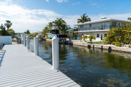a dock with a house and a river at Yeya's Hideaway in Big Pine Key