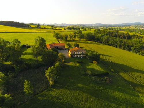 an aerial view of a house in a green field at Ferme de Jeanleix in Sauxillanges