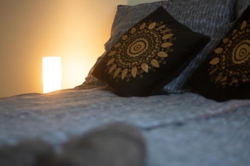 a bed with two pillows on it with a lamp at Becky Apartman in Komló