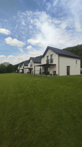 a large white house with a large grass field at Nowa Osada in Łącko
