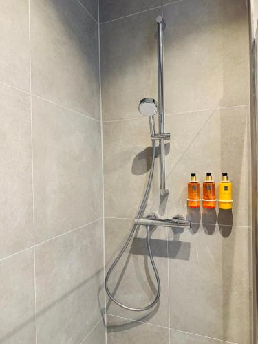 a shower with four bottles of soap in a bathroom at Sunshine Suites in Utrecht