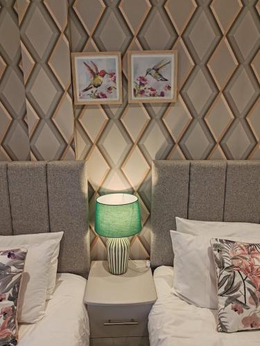 a room with a couch with a lamp on a table at The Cosy Quarters - Popworks in Manchester