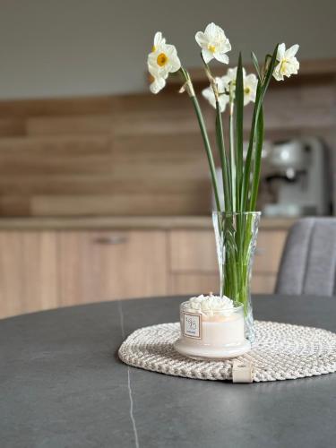 a vase of flowers sitting on a table at Poilsis Kunigiškiuose in Palanga