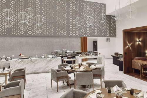 a restaurant with tables and chairs in a room at Wyndham Monterrey Ambassador Centro in Monterrey