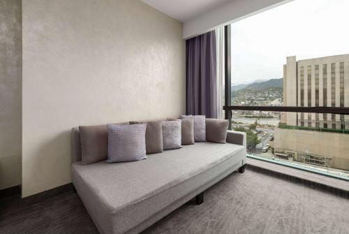 a couch in a room with a large window at Wyndham Monterrey Ambassador Centro in Monterrey