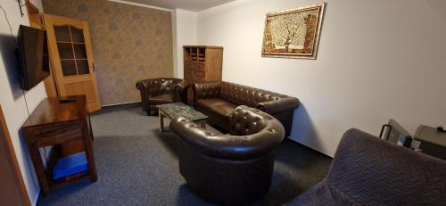 a living room with a leather couch and a table at Vila Jedľa in Smokovce
