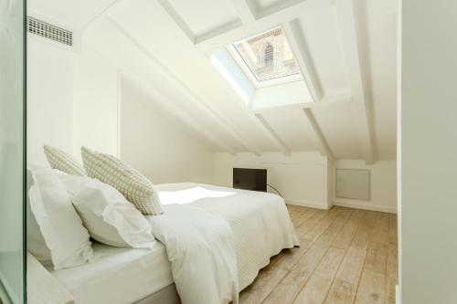 a bedroom with a white bed and a skylight at Traverse Des Artistes in Cannes