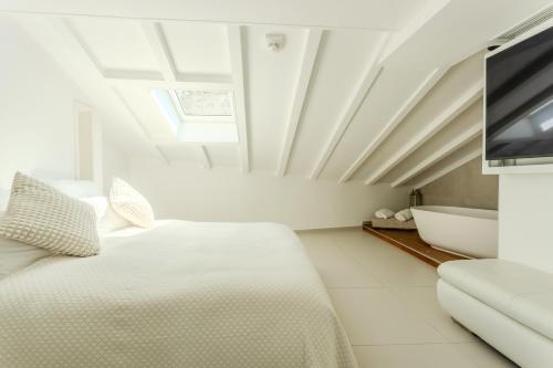 a bedroom with a bed and a tv and a tub at Traverse Des Artistes in Cannes