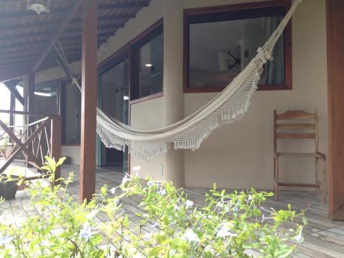a hammock hanging from the side of a house at Bangalô dos Sonhos in Morro de São Paulo