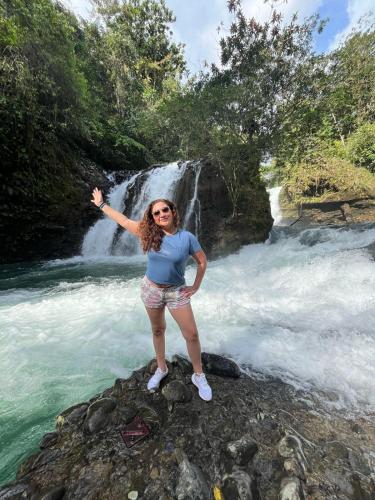 a woman standing on a rock in front of a waterfall at Casa de la Cascada in Pedro Vicente Maldonado