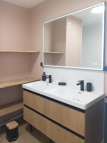 une salle de bain avec un lavabo et un miroir dans l'établissement Superbe T3 moderne vue mer avec parking, climatisation, piscine, à La Grande Motte
