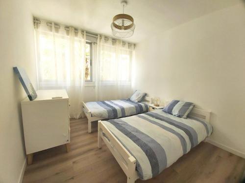une chambre avec deux lits et une fenêtre dans l'établissement Superbe T3 moderne vue mer avec parking, climatisation, piscine, à La Grande Motte