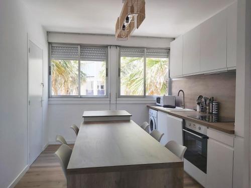 une cuisine avec une table et des chaises dans l'établissement Superbe T3 moderne vue mer avec parking, climatisation, piscine, à La Grande Motte