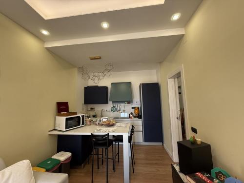 a kitchen with a table with chairs and a microwave at Frida in San Giorgio a Cremano