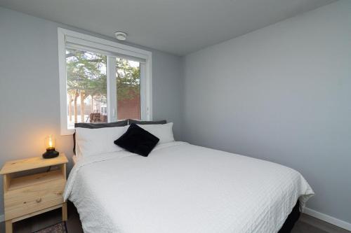 a bedroom with a white bed and a window at Coliseum - Get Back To Nature in Nordegg