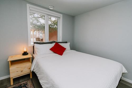 Un dormitorio con una cama blanca y una ventana. en Eagle - Cozy Tiny Home With Mountain Views, en Nordegg