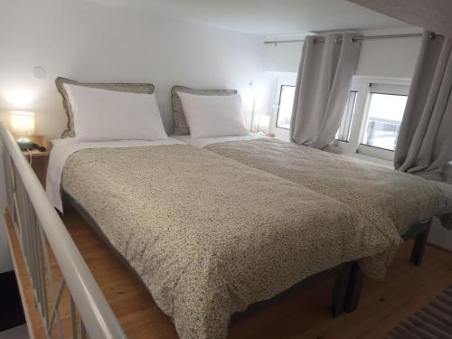 a bedroom with a large bed with white sheets and pillows at George and Helen's Studio in Corfu