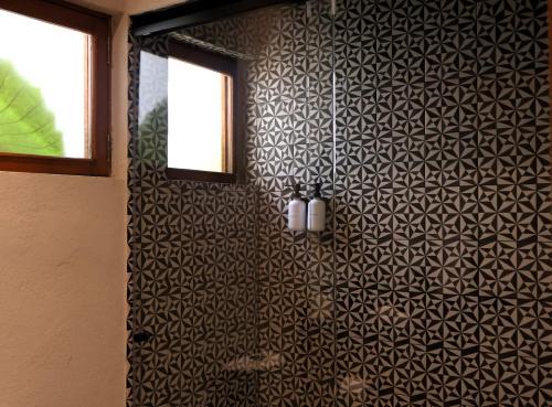 a bathroom with a black and white patterned wall at Hacienda Álamos in Laborcillas