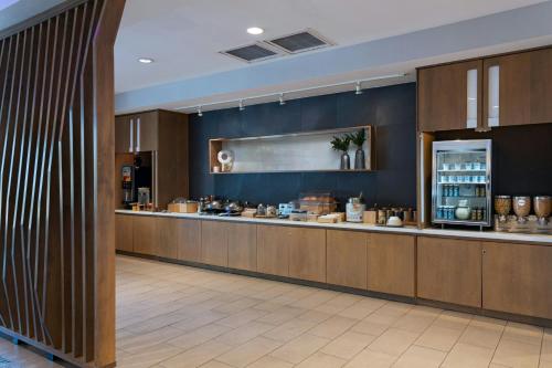 a large kitchen with a counter in a restaurant at SpringHill Suites by Marriott Austin Cedar Park in Cedar Park