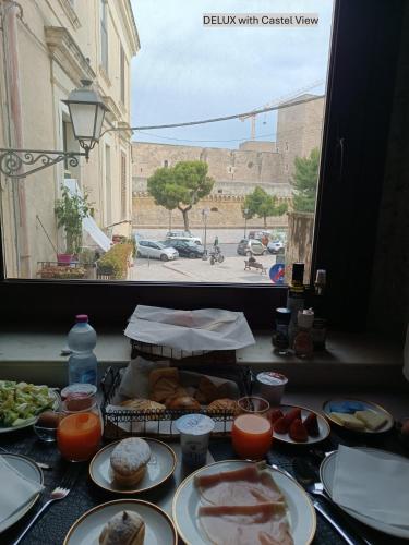 a table topped with plates of food next to a window at Dimora Arco Basso - Old Town in Bari