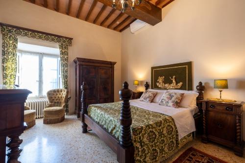a bedroom with a bed and a chair at castello di sovicille in Sovicille