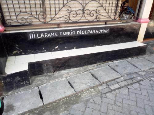 a bench with the words dianeianeaeus farkannis parabisabis dog at Hotel O Homestay Rungkut Syariah in Surabaya