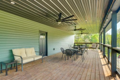 a covered deck with a couch and tables and chairs at Near Wineries Country Condo in New Haven in New Haven