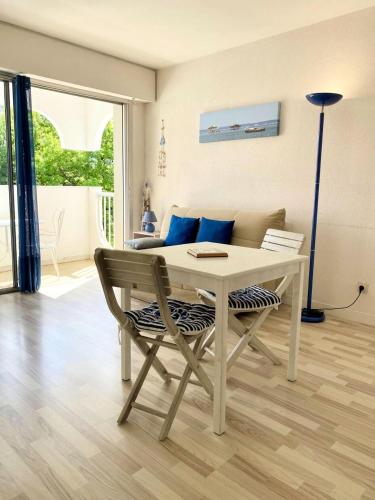 d'une table et d'une chaise dans le salon. dans l'établissement Résidence Bailli De Suffren - Studio à Arcachon, proche plage et commerces MAE-8504, à Arcachon