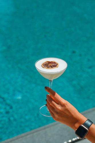 a person holding up a drink in a martini glass at Casa Lumar Luxury Lodging- Adult Only in Fethiye