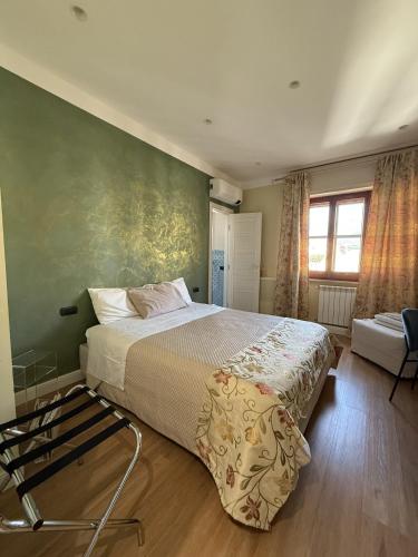 a bedroom with a bed and a green wall at Frida in San Giorgio a Cremano