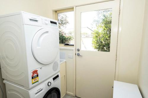 a laundry room with a washing machine and a window at Paradise on Pascoe in Apollo Bay