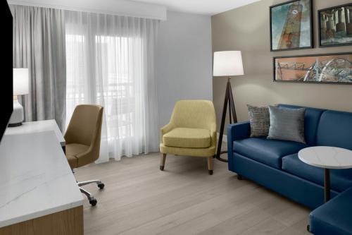 a living room with a blue couch and a chair at Residence Inn by Marriott Daytona Beach Oceanfront in Daytona Beach