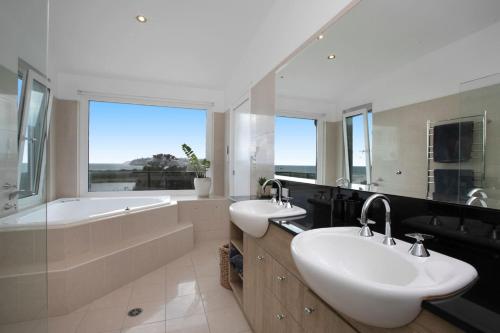 CollaroySpacious Oceanview Escape with Pool and Cabana的一间带两个盥洗盆、浴缸和窗户的浴室