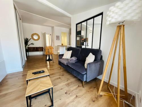 a living room with a blue couch and a table at Le Cocon Perché in Valence