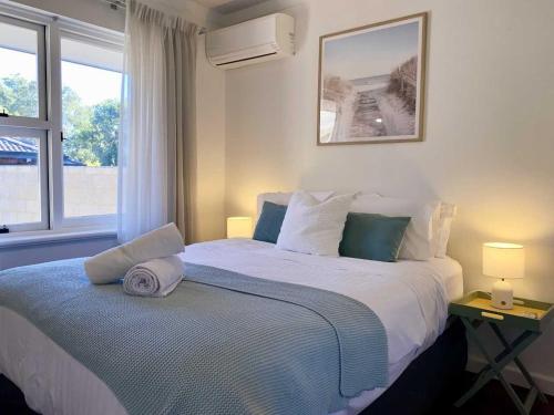 a bedroom with a large bed with a window at Bayswater Retreat, 3 Bed house. in Perth