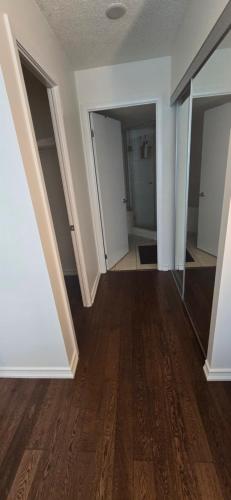 an empty room with white walls and wood floors at Lovely condo near Lake Ontario in Toronto
