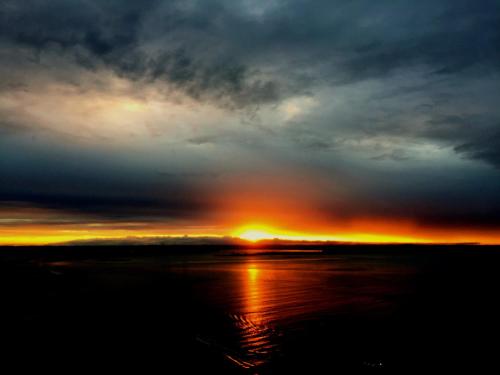 a sunset with the sun setting in the horizon at Bangalô dos Sonhos in Morro de São Paulo