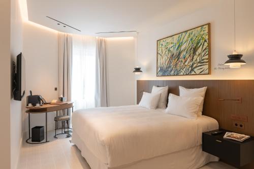 a hotel room with a bed and a desk in it at Château Rose Golfe de Saint Tropez-Grimaud in Grimaud