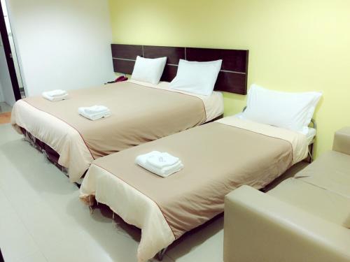 two beds sitting next to each other in a room at Diamond Bangkok Apartment in Bangkok