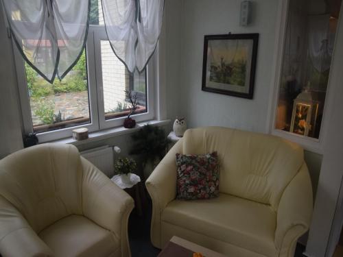 a living room with two chairs and two windows at Charmantes Dachgeschoss-Refugium, Harz in Wildemann