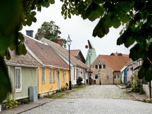 a cobblestone street with houses and a church at Hotell Hamngatan 27 in Falkenberg